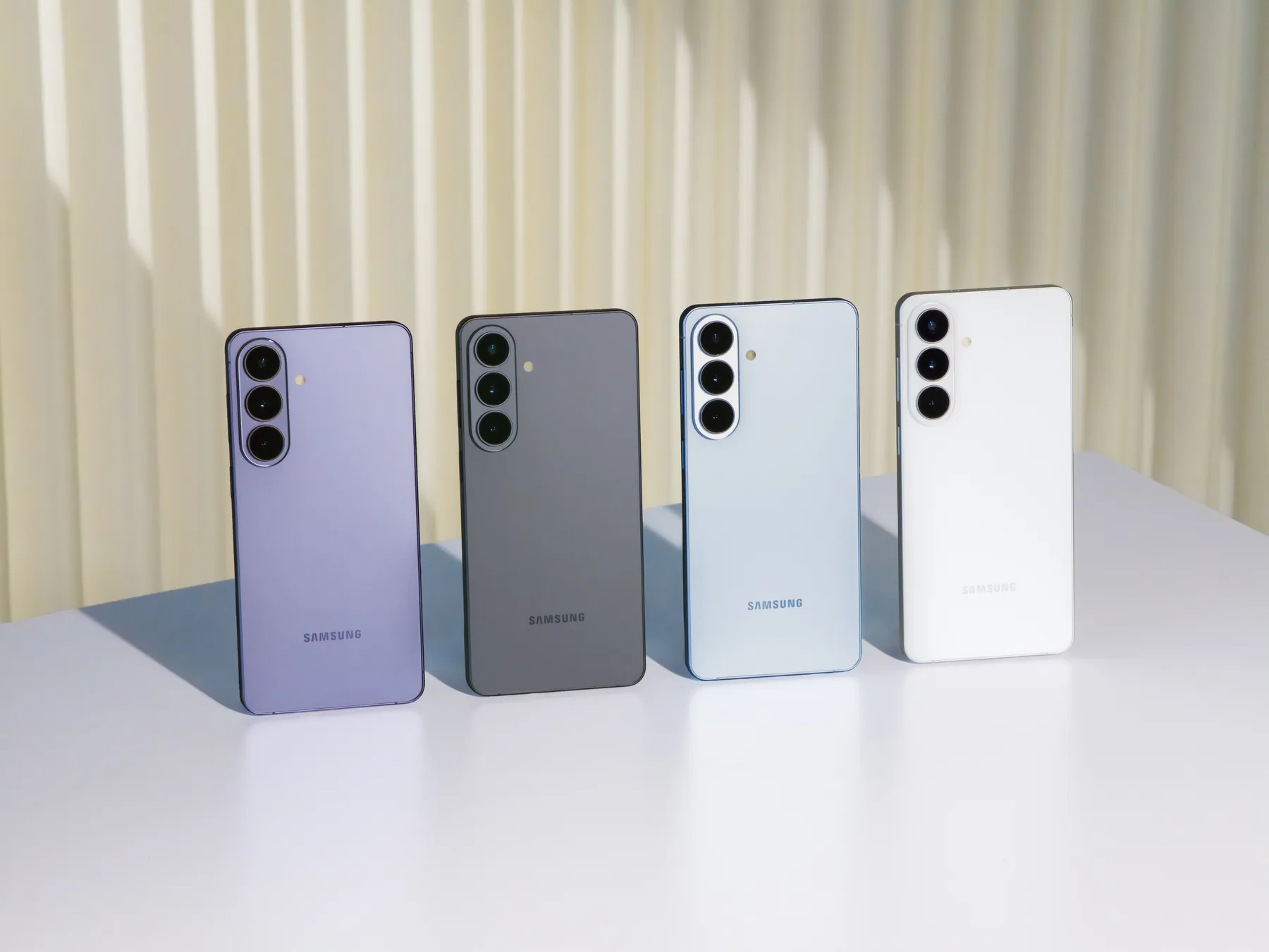 Galaxy S26 series phones in Cobalt Violet, Black, Sky Blue and White standing in a row